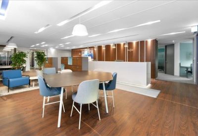 Spacious open-plan reception area with warm wood floors and modern seating.