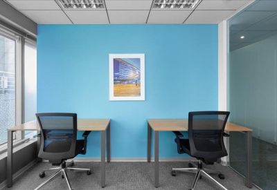 Private two-person office suite featuring a vibrant blue feature wall and natural light.