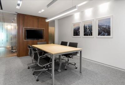 Professional four-person meeting room with wood paneling and black leather chairs.