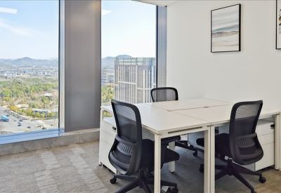 Bright corner office with desks for four and panoramic city views.