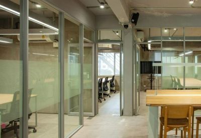 Modern glass-walled corridor leading to private office suites.