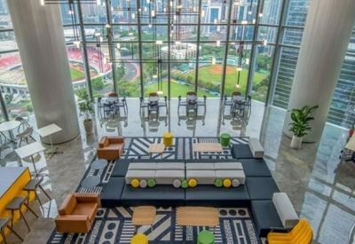 Spacious co-working area with tiered seating, modern rugs, and a wide view of a sports stadium.