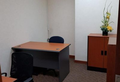 Private internal office with two wooden desks and a storage cabinet.
