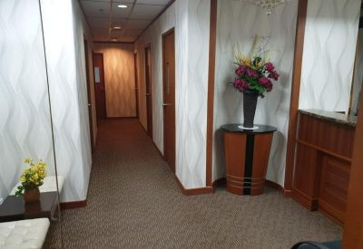 Office corridor featuring wavy patterned wallpaper and warm wooden door frames.