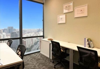 Professional meeting room with a white table, black chairs, and a wall-mounted screen.