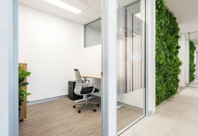 Private office suite with a green living wall, timber flooring, and a single workstation.