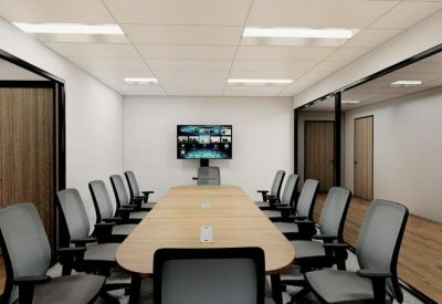Professional boardroom with a long wooden table and integrated video conferencing technology.