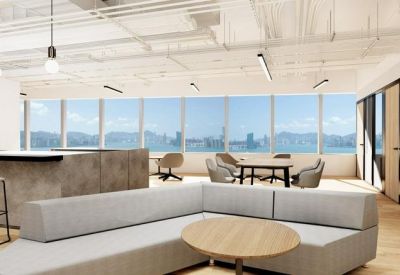 Bright breakout space with a grey sectional sofa and panoramic harbor views.