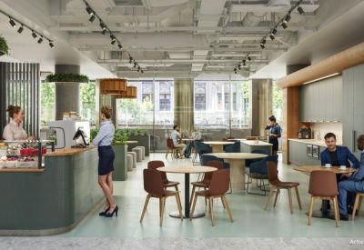 Bright communal café and breakout space with round tables, chairs, and an service counter.