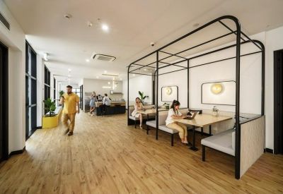 Unique coworking lounge featuring semi-enclosed black frame booth seating.