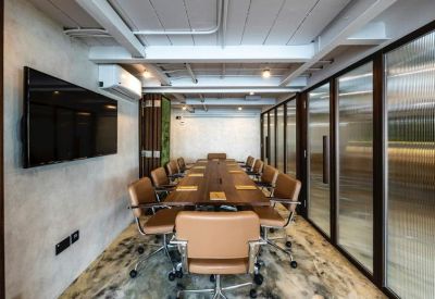 Modern meeting room with a large wooden table, leather chairs, and a glass partition wall.