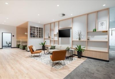 Inviting communal lounge with leather armchairs, a white sofa, and light wood cabinetry.