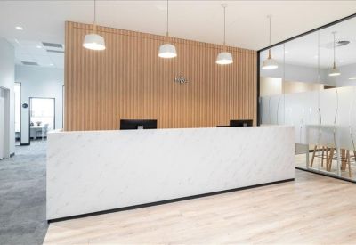 Modern reception area featuring a white marble desk and wood-slatted feature wall.