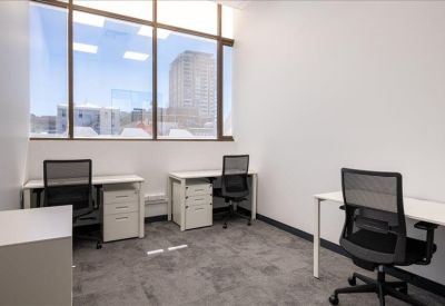 Private office suite with two workstations and a large window overlooking the city.