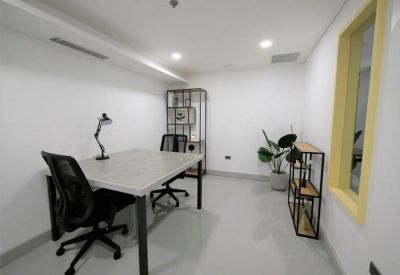 Internal two-person office suite with a minimalist white desk and black mesh chairs.