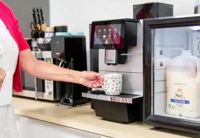Communal kitchen area featuring a professional coffee machine and refreshments.