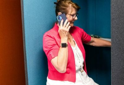 Private soundproof phone booth with blue acoustic padding and a comfortable seat.