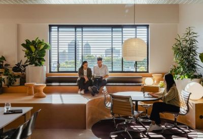 Spacious communal lounge featuring tiered wooden seating and large windows.