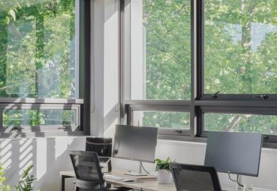 Bright open-plan office with multiple workstations near large windows.