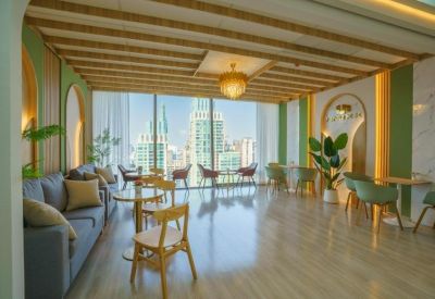 Spacious communal lounge with plush seating and an arched entrance overlooking the city skyline.