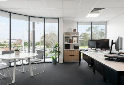 Private office suite featuring a round meeting table, workstations and a window view.