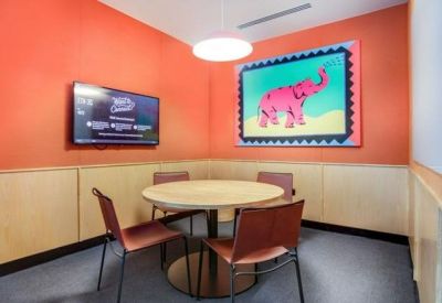 Small meeting room with orange walls and a pink elephant stamp artwork.