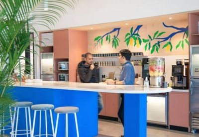 Cafe area with a blue counter and vibrant botanical wall mural at 2F, Embassy Quest.