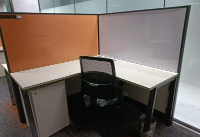 Single corner workstation with orange and white privacy panels and an ergonomic chair.
