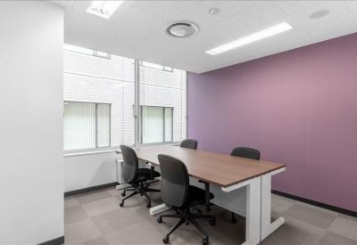 Modern internal office suite with a purple feature wall and meeting table.