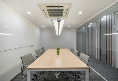 Professional conference room with a long wooden table, grey chairs, and a white whiteboard.