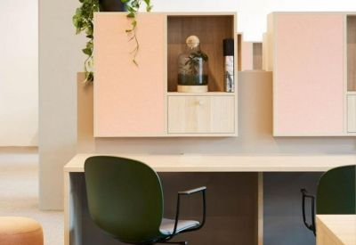 Modern workstation with a green chair, light wood desk, and built-in storage cabinets.