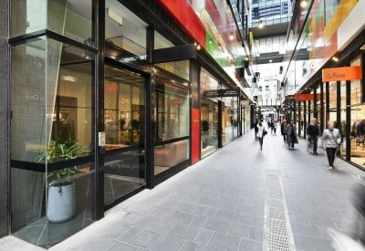Building entrance located within a modern glass-fronted retail and office arcade.
