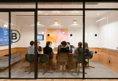 Glass-walled meeting room with a large table and professional presentation screen.