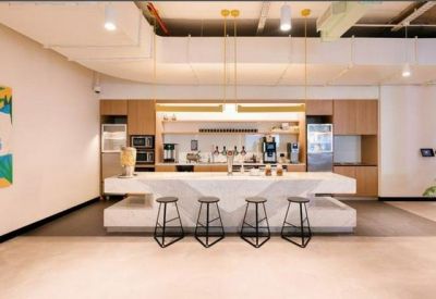 Sleek kitchen and breakroom area with a marble island and bar stools.