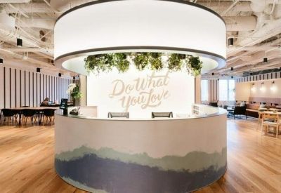 Modern reception area with a circular front desk and Do What You Love neon signage.