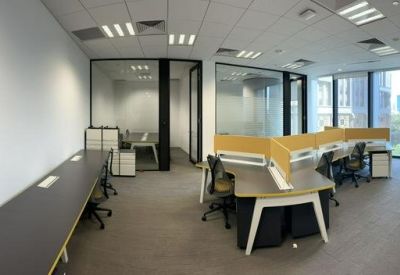 Bright open-plan office with clustered workstations and glass partitions.