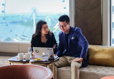 Coworking space featuring a laptop on a small table and a view of the Singapore Flyer through the window.