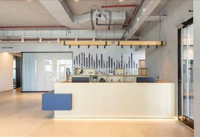 Reception area featuring a sleek white front desk with blue accents and wooden light fixtures.