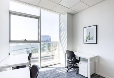 Bright private office with two desks and a large window.