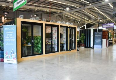 Modern coworking entrance featuring modular glass-fronted offices and indoor plants.