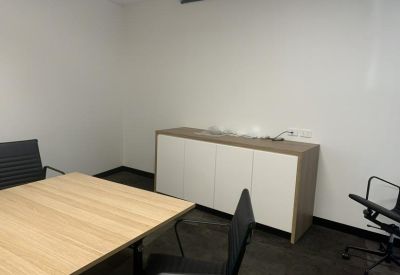 Private office featuring a wooden desk and a white storage sideboard.