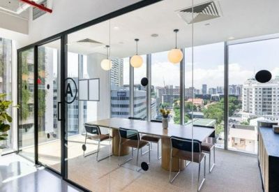 Glass-walled conference room with a long wooden table and panoramic city views.