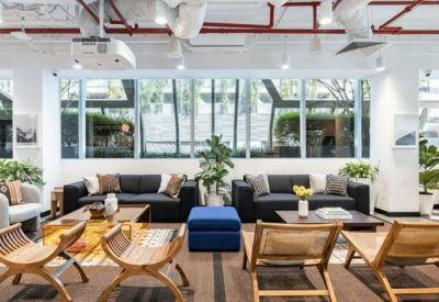 Spacious breakout area with various seating options including sofas and blue ottomans.