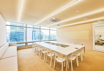 Large minimalist conference room with a hollow square table and floor-to-ceiling windows.
