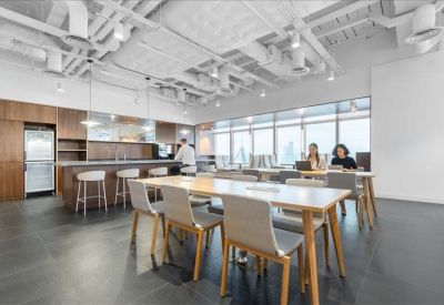 Spacious communal kitchen and dining area with modern wooden cabinetry and island seating.