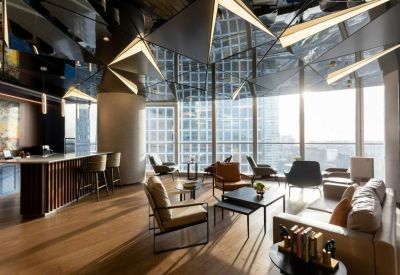 Stylish lounge area with designer armchairs, wooden floors, and a sculptural geometric ceiling.