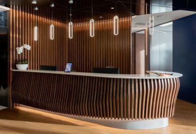 Modern reception desk featuring a curved wooden slat design and elegant pendant lighting.
