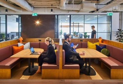 Wooden breakout booths with comfortable bench seating and laptop workstations.