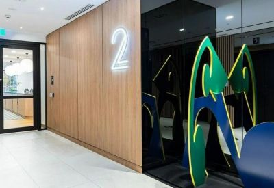 Office corridor featuring a wooden panelled wall with floor number signage and frosted glass partitions.