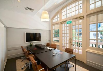 Professional meeting room featuring a large dark table and arched glass doors.